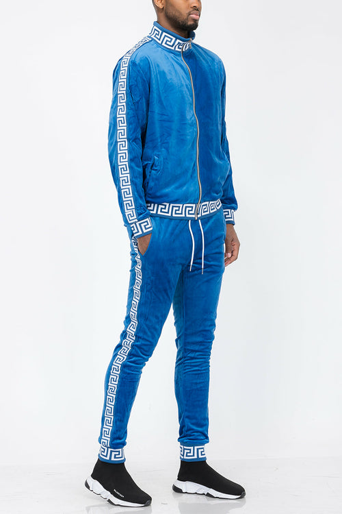 Man wearing a blue tracksuit with white patterns on a white background