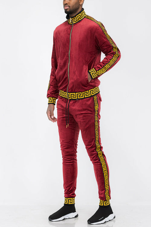 Red tracksuit with gold accents worn by a person on a white background