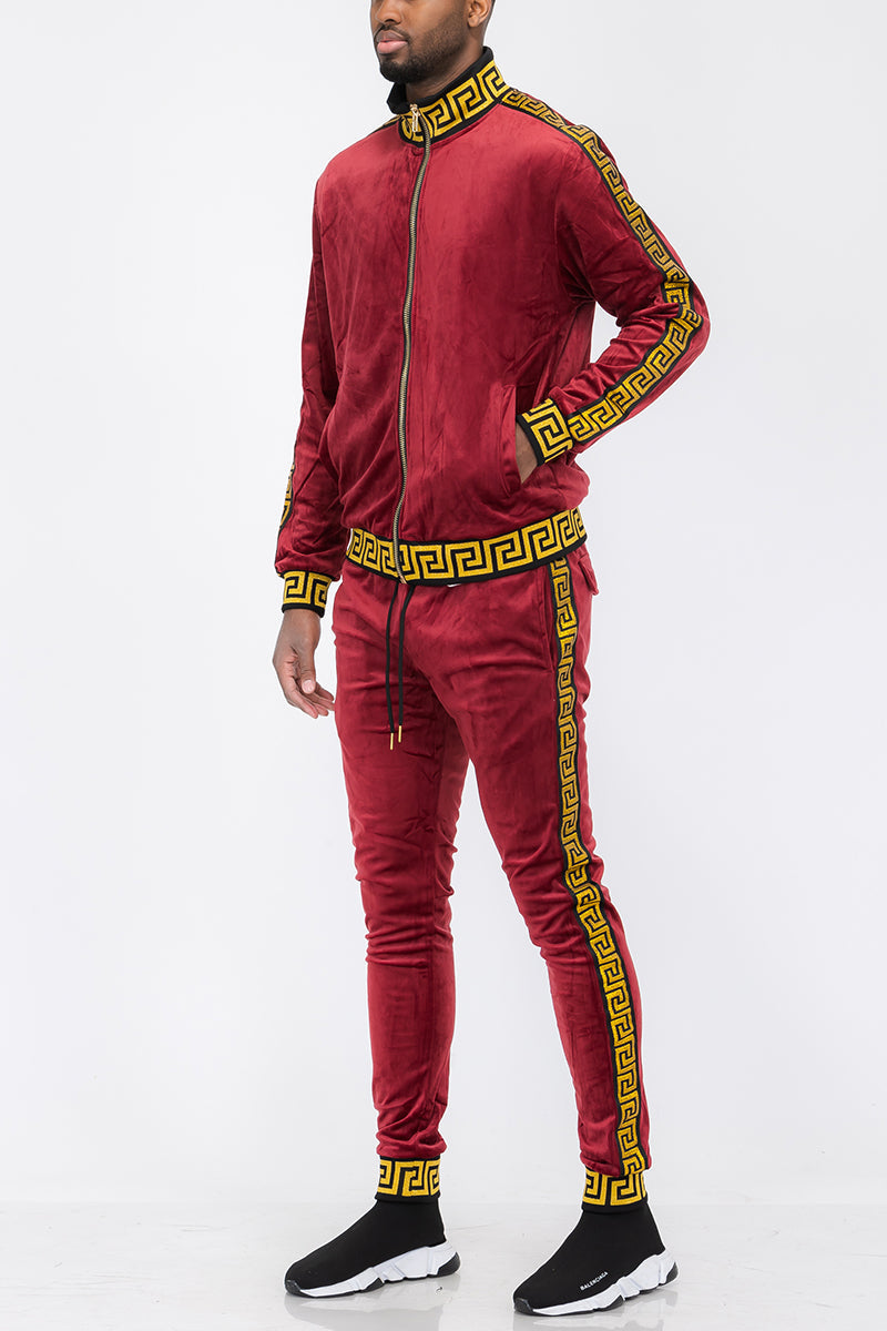 Red tracksuit with gold accents worn by a person on a white background