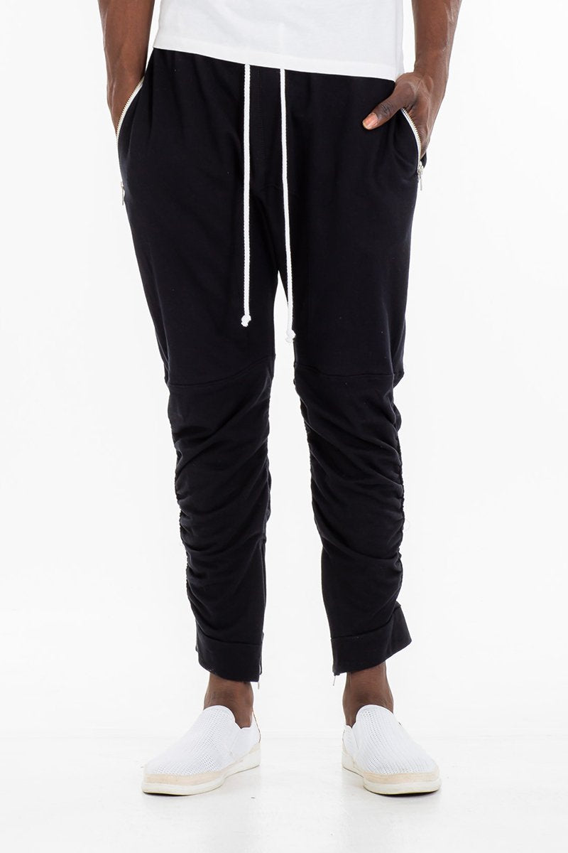 Person wearing black jogger pants with a white drawstring on a white background
