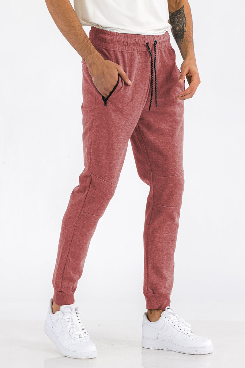 Person wearing red jogger pants with a white background