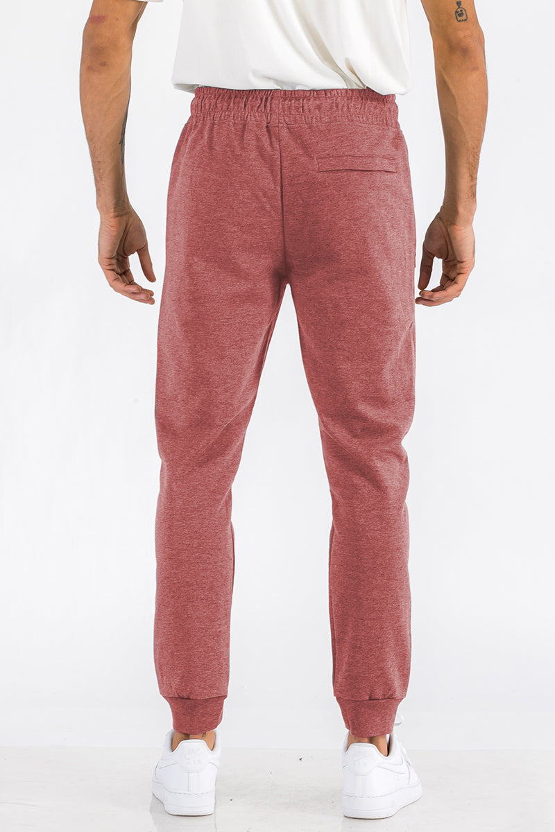 Person wearing red jogger pants on a white background